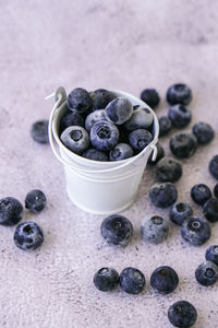 Frozen blueberries in small bucket on concrete background. healthy organic seasonal fruit 