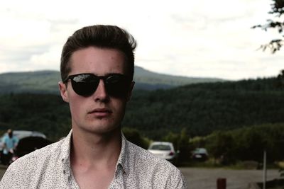 Portrait of young man in sunglasses against sky