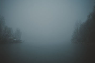 Scenic view of trees against sky during foggy weather