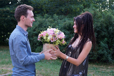 Side view of man and daughter standing against plants