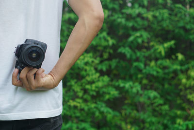 Midsection of man photographing camera