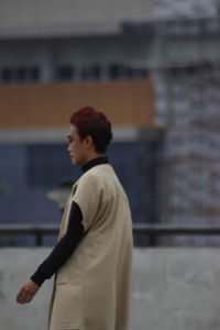 Side view of young man looking at building