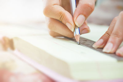 Close-up of hand holding pen on table