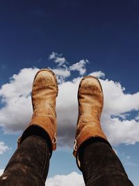 Low section of person against blue sky