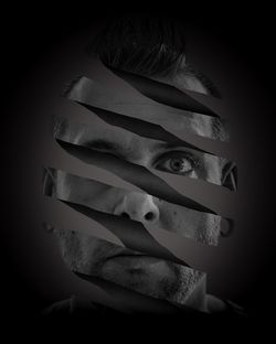 Close-up portrait of young woman over black background