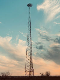 Low angle view of silhouette electricity pylon against sky during sunset