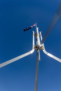 Low angle view of wind turbine against blue sky