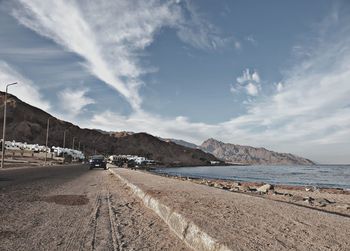 Road by sea against sky