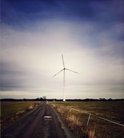 Road by field against sky