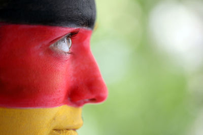 Side view of soccer fan with german flag painted on face