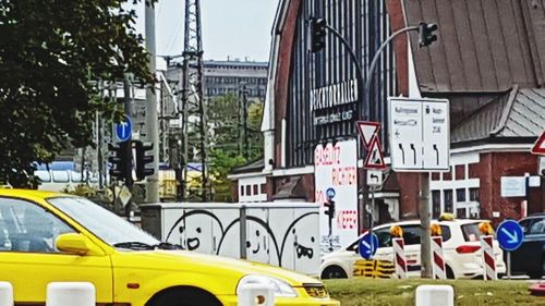 Cars on road by buildings in city