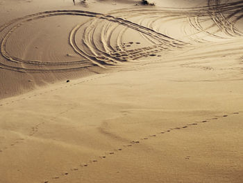 High angle view of tire tracks on sand