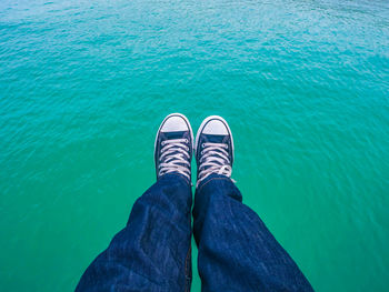 Low section of person wearing shoes in swimming pool