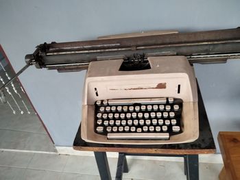 High angle view of old telephone on table against wall