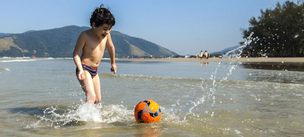 Full length of shirtless boy in water