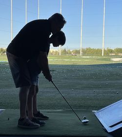 Rear view of man standing on golf course