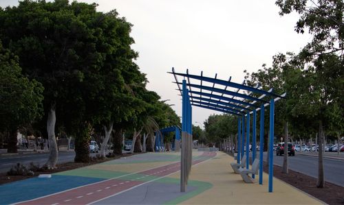 People walking on footpath in park against sky