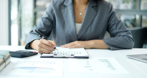 Midsection of business colleagues working on table