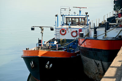 Boat moored at harbor against sky