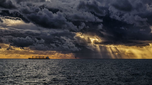 Scenic view of sea against storm clouds