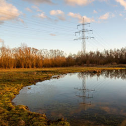 Reflection of power pylon on lake in fall 