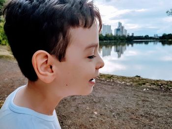 Boy by lake on field
