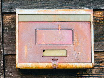 Close-up of weathered box on brick wall