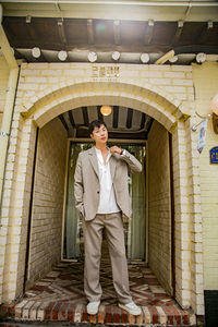 Portrait of a smiling man standing at entrance of building