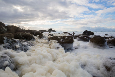 Rocks in sea against sky