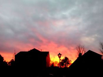 Silhouette of house against dramatic sky