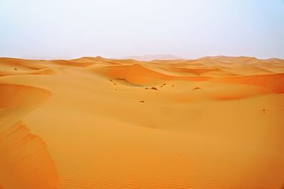 Sand dunes in desert against clear sky