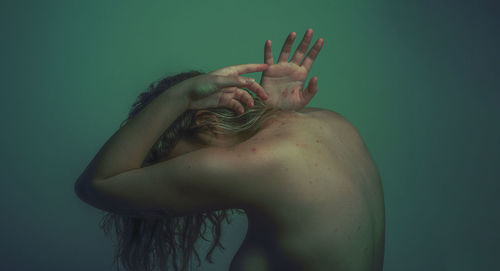 Close-up of human hand against blue background