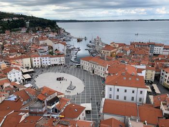 High angle view of townscape by sea against sky