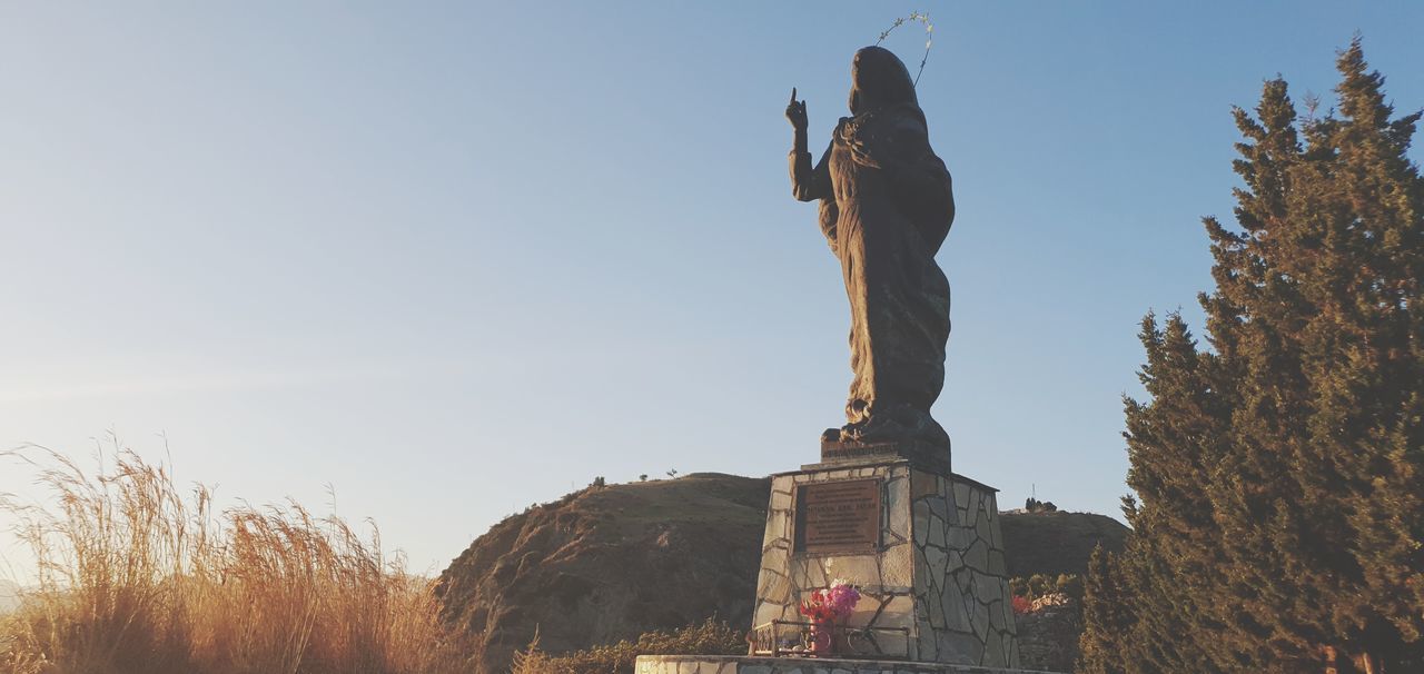 sky, sculpture, statue, nature, human representation, architecture, representation, landmark, travel destinations, history, monument, clear sky, the past, travel, tree, plant, morning, memorial, no people, male likeness, craft, outdoors, religion, day, low angle view, built structure, creativity, tourism, blue, belief