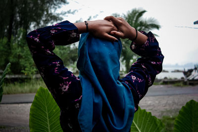 Midsection of woman standing against purple plants