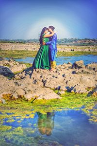 Full length of young couple standing in sea