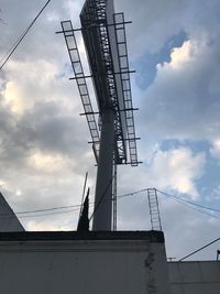 Low angle view of electricity pylon against sky