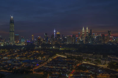 Illuminated cityscape against sky at night