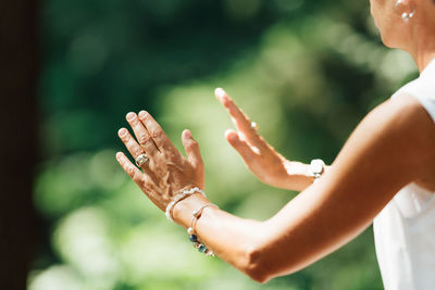 Middle aged woman practicing tai chi chuan in the park. close up on hands position