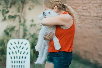 Portrait of woman hugging her dog