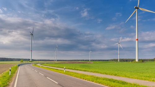 Road amidst field against sky