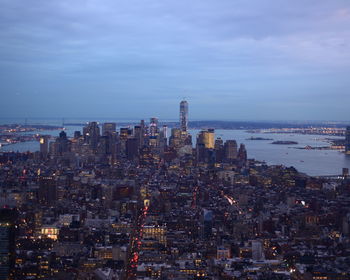 High angle view of illuminated buildings against river at manhattan