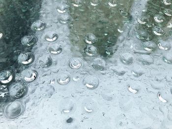 High angle view of raindrops on glass