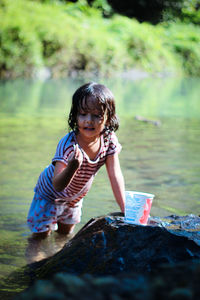 Full length of cute girl holding water