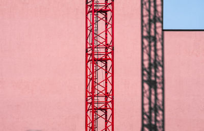 Low angle view of crane at construction site against sky