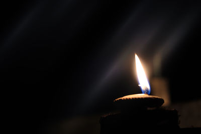 Close-up of burning candle in darkroom