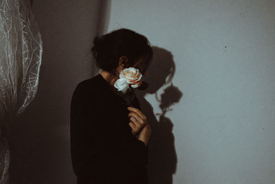 Woman standing against wall at home