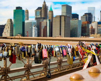 Love locks on railing of brooklyn bridge against city