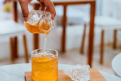 Close-up bartender pouring cocktail  of drink served on table