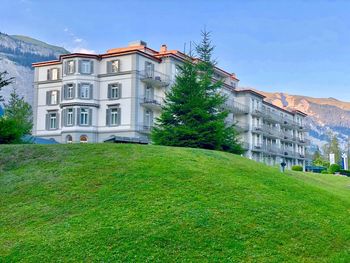 Building by lawn against sky